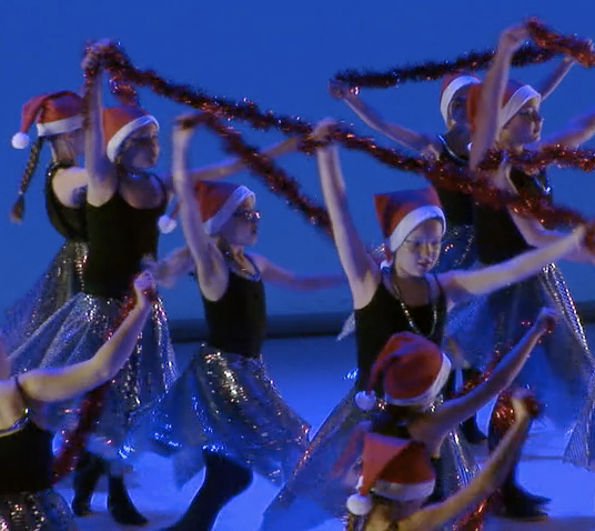 Fillettes qui dansent avec guirlandes et chapeau de père noël